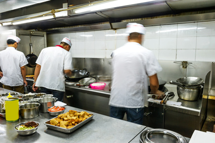Crowded kitchen, a narrow aisle, working chef.